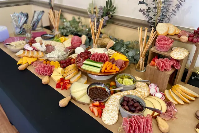 A beautifully arranged charcuterie board featuring various meats, cheeses, fruits, and crackers.