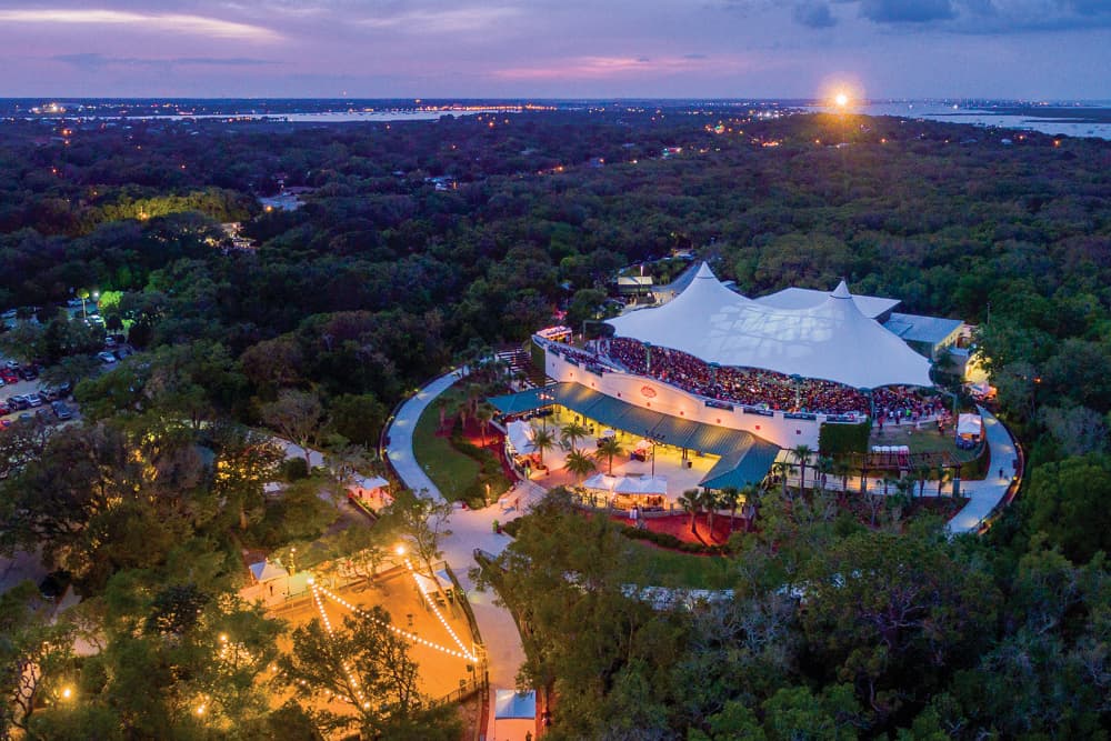 Aerial view of a large outdoor amphitheater surrounded by trees during twilight.