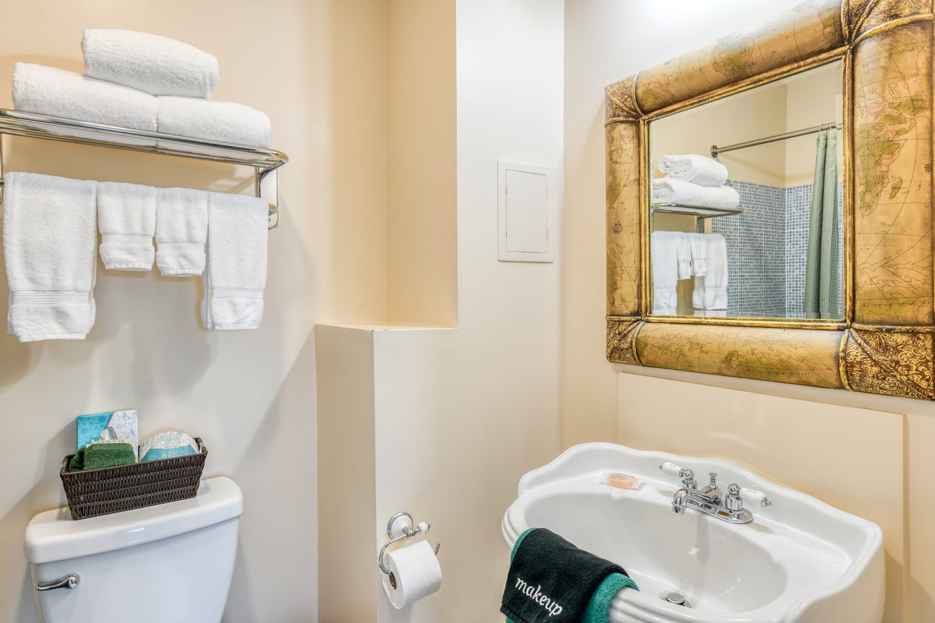 A clean bathroom featuring a sink, toilet, and neatly arranged towels.