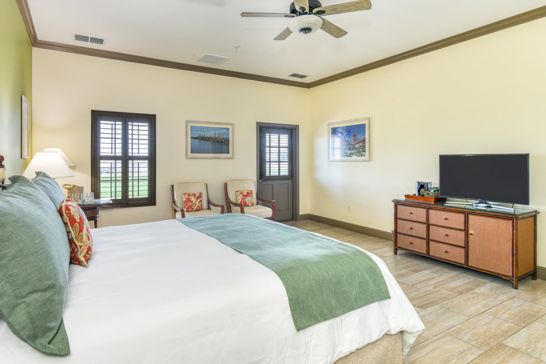 A cozy hotel room featuring a bed, seating area, and a TV.